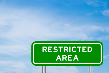 Green color transportation sign with word restricted area on blue sky with white cloud background