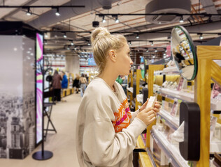 Woman choosing powder and testing makeup brush, palette of powder and foundation .	