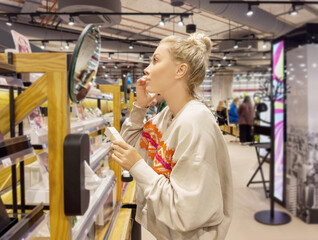 Woman choosing powder and testing makeup brush, palette of powder and foundation .	
