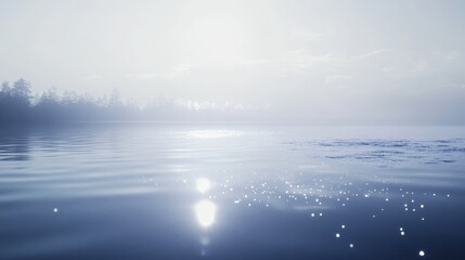 Fototapeta premium Calm water under a hazy sky at dawn.