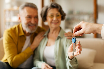 Real estate offer. Agent giving key to senior buyers couple, spouses buying apartment. Mortgage,...