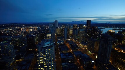 Fototapeta premium Aerial View of City Skyline at Dusk with Illuminated Buildings