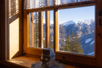 Snowy mountain view from a cozy cabin window during a clear winter morning