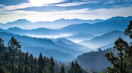 Obraz premium Serene Mountain Landscape with Layered Peaks and Misty Atmosphere in Soft Blue Tones at Sunrise