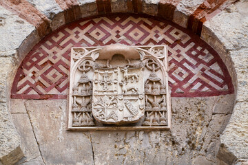 Cordoba, Spain - 28 October, 2024: Coat of arms on the facade of the building Mosque Cathedral