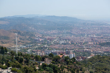 Barcelona cityscape expanding towards the sea with cargo ships waiting in the harbor
