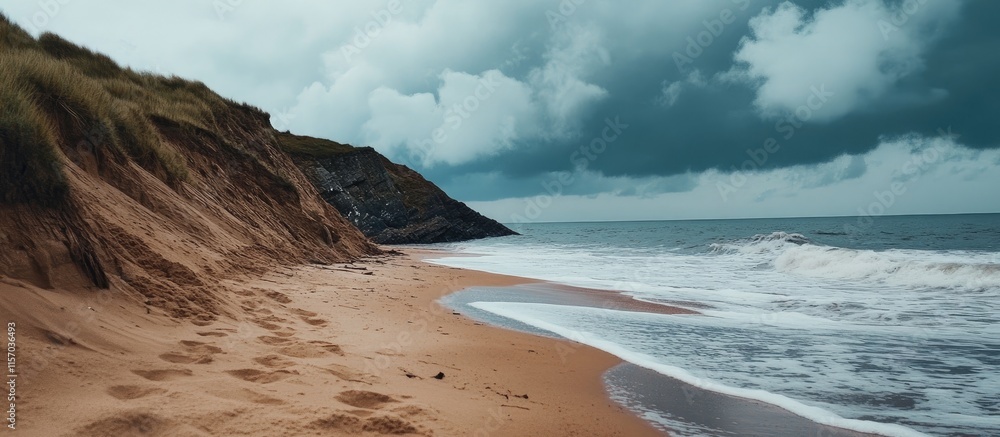 Poster waves rolling onto a sandy beach under dramatic cloudy skies creating a moody coastal scene