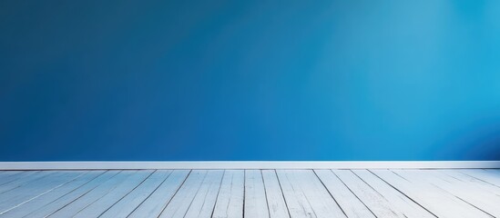 Bright blue wall with white wooden floor creating a spacious minimalistic interior design concept for backgrounds and displays