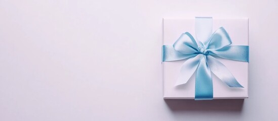 Elegant white gift box adorned with a delicate blue ribbon bow isolated on a clean white background for festive occasions and celebrations.