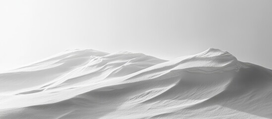 Fototapeta premium Serene winter landscape of white snow-covered hills under a soft grey sky creating a minimalist and tranquil atmosphere