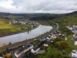 Fototapeta premium Aerial view of terraced vineyards around Nittel, Rhineland-Palatinate, Germany and views across Moselle River on vineyard hills of Machtum, Luxembourg
