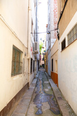 Obraz premium Narrow street leading to archway in spanish town