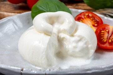 Cheese collection, eating of fresh soft white burrata cheese ball made from mozzarella and cream...