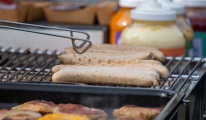 German streetfood, many BBQ wood-fired or charcoal-grilled sausages wurst ready to eat in outdoor cafe, picnic