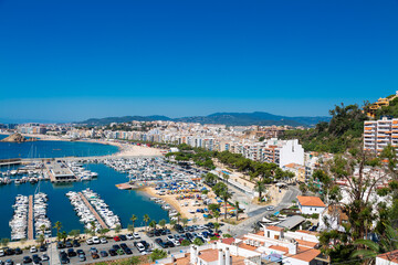 Blanes cityscape with harbor, beach and sa palomera rock in summertime