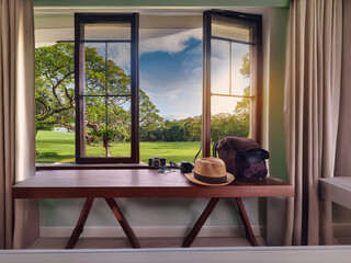 A tranquil room with a window showcasing a lush green landscape.  Sunlight streams in, illuminating...