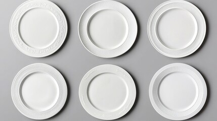 Set of nine white plates each with unique ornamental designs isolated on a gray background