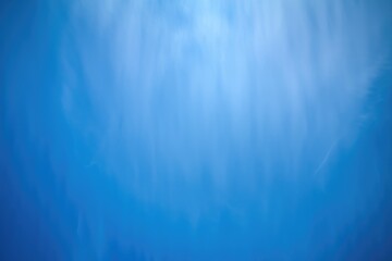 A vibrant blue sky with subtle, wispy clouds creating a serene and peaceful atmosphere.