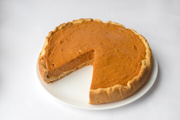 Pumpkin pie with caramel sauce on the white background. Traditional cake. Ready to eat. Cooking concept. Halloween time