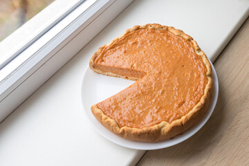 Pumpkin pie with caramel sauce on the white background. Traditional cake. Ready to eat. Cooking...