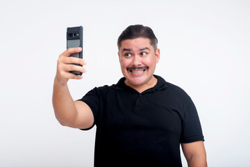 A socially inept middle-aged man takes an awkward looking selfie. Isolated on a white background.