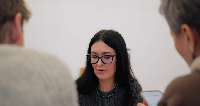 Focused woman actively participating in brainstorming session, generating creative ideas and contributing to collaborative solutions during dynamic professional discussion. company employees gather