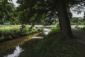 A park with a river gently winding through greenery and trees