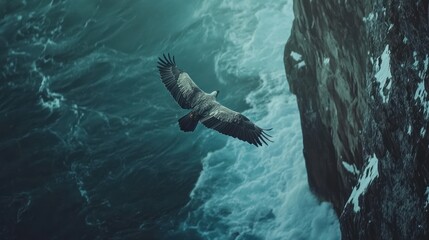 Fototapeta premium Majestic eagle soaring over dramatic ocean waves near a cliff.