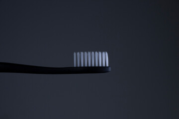 Black toothbrush with White bristles close-up on a Black background