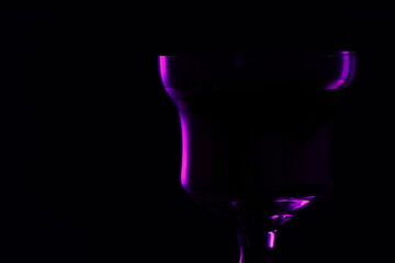 Purple neon glass isolated on a pure black background.