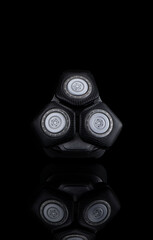 Closeup Image of 3 Blades Electric Shaver On Black Reflective Surface. Vertical image Composition