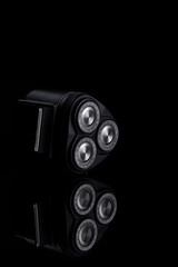 Closeup Image of 3 Blades Electric Shaver On Black Reflective Surface. Vertical image Composition