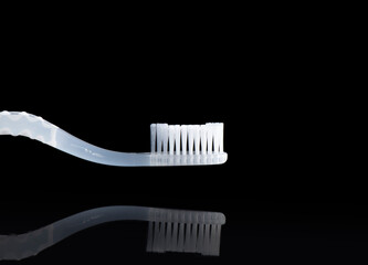 White-translucent toothbrush shot on a pure black background.