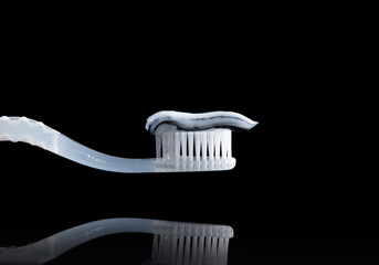 Toothpaste on a toothbrush close-up on a pure black background.