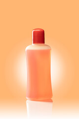 Orange nail polish removal bottle. Isolated on a orange background with a glow.