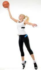 Sexy blonde female basketball player (model) jumping as if to shoot the ball, ball on fingertips
