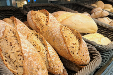Fresh baguettes on a bakery display. Artisan bread shop with crispy golden loaves. Wheat baguettes arranged on a shelf. Freshly baked goods in a store.