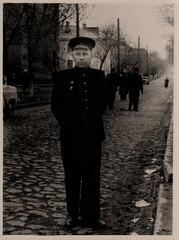 Vintage portrait of a middle-aged man in the uniform of a USSR railway worker on a city street....