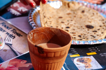 Kulhad tea is served alongside paratha for a morning breakfast. This combination offers a hearty and flavorful start to the day.