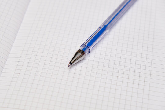 A blank notebook with a black pen lying on top. The notebook is open and ready for writing.
