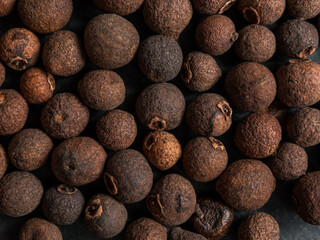 A close-up of black allspice, highlighting the texture and rich color