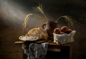 Still life with bread and eggs in a basket on a dark background
