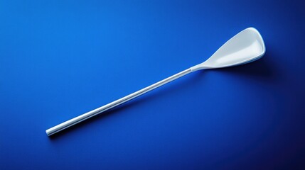 Sleek Stainless Steel Spoon on Vibrant Blue Background