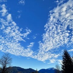 Obraz premium Vast Blue Sky Filled With Fluffy White Clouds Over Mountains During a Sunny Day in the Pacific Northwest