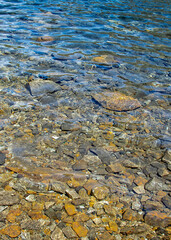 Transparent rocky shore beach detail, nahuel huapi lake, bariloche, argentina