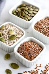 Obraz premium Four small bowls showcase variety of healthy seeds, highlighting