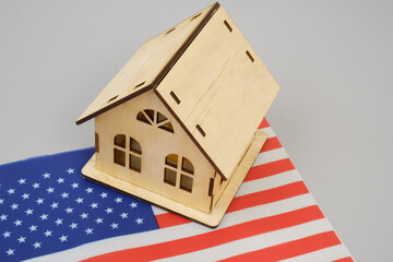 Real estate in United States concept. Wooden house model  on USA flag. 	