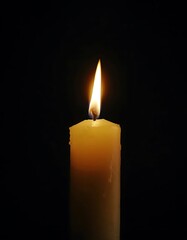 A Single Candle Flame Burning Brightly In The Dark