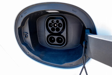 An electric vehicle (EV) charging high-voltage energy at an EV charging station replenishes its...