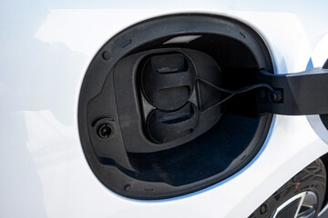 An electric vehicle (EV) charging high-voltage energy at an EV charging station replenishes its...